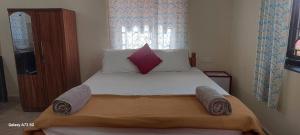 een slaapkamer met een bed met witte lakens en kussens bij Bal Ganesha beach resort in Canacona