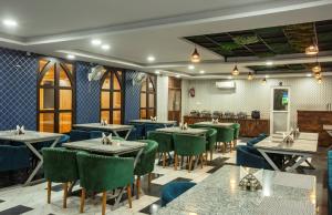 a dining room with tables and green chairs at Hotel Ginger Palace Delhi Airport in New Delhi