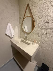 a bathroom with a sink with a mirror on the wall at Pousada Arena 165 in Murici +30 photos