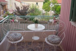 een balkon met twee stoelen en een tafel bij La Casa Rosa in Lefkada