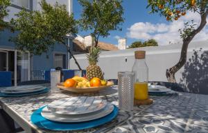 a table with a bowl of fruit and a pineapple at OrangeTreeHouses in Montijo