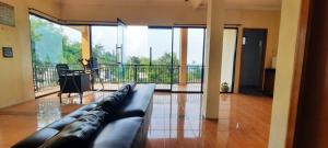 een woonkamer met een leren bank en een balkon bij Villa Montana Batulayang in Sampal 2