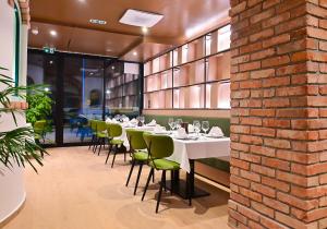 a dining room with tables and chairs and a brick wall at Hotel Risnjak in Delnice