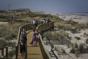 a group of people walking down a wooden boardwalk to the beach at Bird’s Home in Aveiro +61 photos