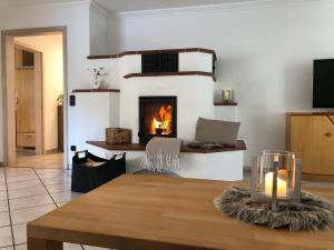 a living room with a fireplace and a table at Ferienwohnung Ottenzeller Haisl in Arrach