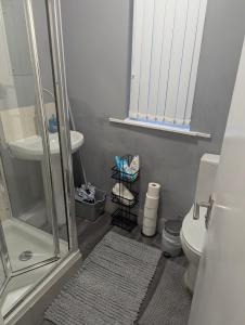 ein Badezimmer mit Dusche, Toilette und Waschbecken in der Unterkunft GlowHavenStay in Manchester