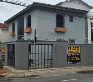a building with a gate with a sign on it at FLATS MELO unimontes in Montes Claros