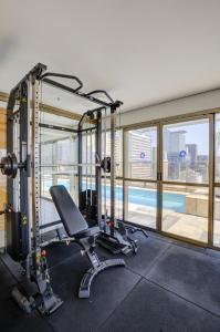a gym with a treadmill and a swimming pool at Transamerica Executive Paulista in São Paulo
