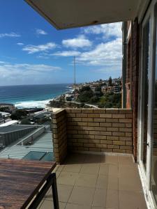 een balkon met een bakstenen muur en uitzicht op de oceaan bij Beach & Ocean View Apartments Tamarama in Sydney +4 foto's