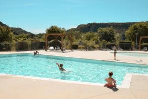 a group of people playing in a swimming pool at ZEcamping 3 étoiles pet friendly avec piscine et pataugeoire in Les Assions +34 photos