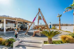 a child standing in front of a playground at The Amethyst Exclusive Suites Oia in Oia +15 photos