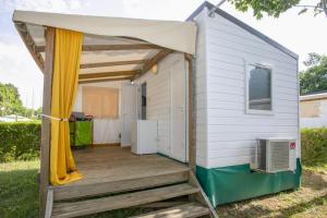 a tiny house with a porch and awning at ZEcamping 4 étoiles dog friendly bien-être restaurant et soirées animées in Foix