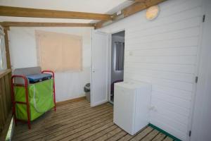 a room with a door and a small refrigerator at ZEcamping 4 étoiles dog friendly bien-être restaurant et soirées animées in Foix