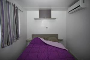 a bedroom with a purple bed in a room at ZEcamping 4 étoiles dog friendly bien-être restaurant et soirées animées in Foix