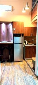 a kitchen with a stainless steel refrigerator and wooden cabinets at Apartment Cabin-Style in Belgrade