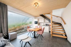 a kitchen and dining room with a table and a staircase at StoderLodge - Alpine Garden Residence - by myNests in Gröbming