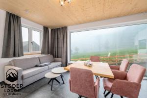 a living room with a couch and a table at StoderLodge - Alpine Garden Residence - by myNests in Gröbming +31 photos