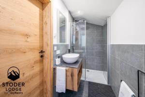 a bathroom with a sink and a shower at StoderLodge - Alpine Garden Residence - by myNests in Gröbming