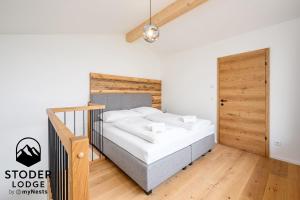 a bedroom with a bed and a wooden door at StoderLodge - Alpine Garden Residence - by myNests in Gröbming