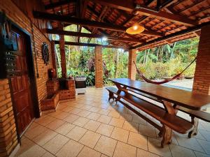 un banc en bois dans une pièce avec patio dans l'établissement Suíte Iberê - Pousada Jussara, à Joinville