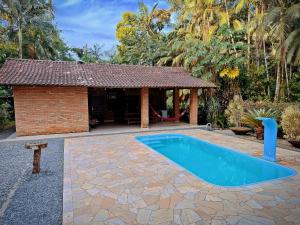 - une piscine dans une cour avec un pavillon dans l'établissement Suíte Iberê - Pousada Jussara, à Joinville