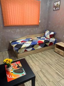 a small bedroom with a bed and a table at Квартири ЦЕНТРАЛ in Dolna Mitropoliya