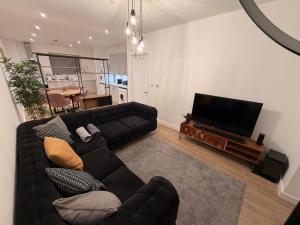 a living room with a couch and a flat screen tv at HRF Barking Apartments in Barking