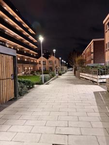 an empty street at night with buildings and lights at HRF Barking Apartments in Barking