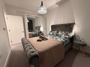a bedroom with a bed with a headboard and a mirror at HRF Barking Apartments in Barking