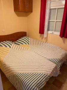 een groot bed in een slaapkamer met een raam bij Mobil Home sans vis a vis in Saint-Georges-de-Didonne +12 foto's