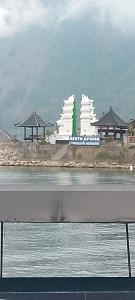 a view of a white building on the side of the water at Villa bungalow restoApung in Kubupenlokan