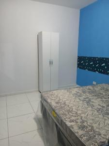 een kamer met een bed en een witte kast bij Casa aconchegante e familiar em Matinhos in Matinhos +7 foto's