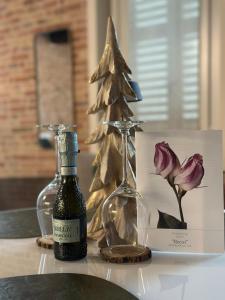 eine Flasche Wein und ein Weihnachtsbaum auf dem Tisch in der Unterkunft Noua Luxury Studio Apartments in Ravenna