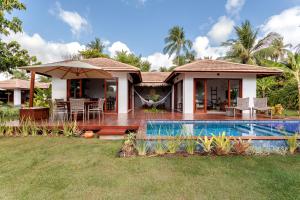 a house with a swimming pool in front of it at Tua Pousada Boutique Tatuamunha, Rota Ecológica dos Milagres, Porto de Pedras, Alagoas in Tatuamunha