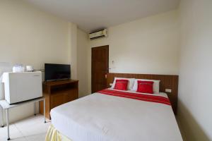 a bedroom with a large white bed with red pillows at Ashiraya hostel in Kata Beach