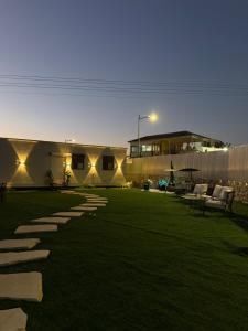 a yard with chairs and a building at night at אחוזת תכשיט in Sifsufa