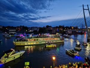 a group of boats in a river with people on them at Apartamenty przy Promenadzie mieszkania w ścisłym centrum in Mikołajki
