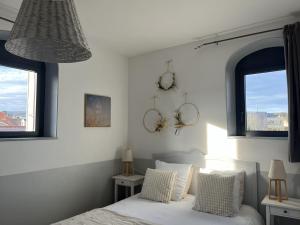 a bedroom with a bed with two clocks on the wall at La Poterne l Chambres d'hôtes à Epernay in Épernay