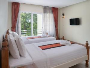 two beds in a hotel room with a window at Amphawaree Hotel in Samut Songkhram +46 photos