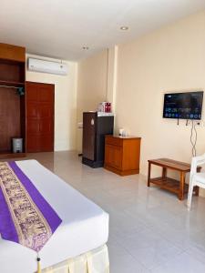 a hotel room with a bed and a tv at Ashiraya hostel in Kata Beach