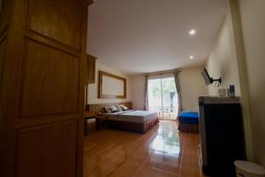 a room with a bedroom with a bed and a window at Ashiraya hostel in Kata Beach +2 photos