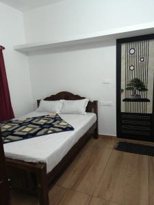 een slaapkamer met een bed en een raam bij Holidays Homestay Vagamon in Vagamon