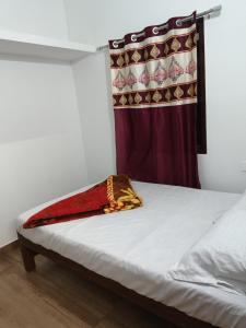 een bed in een kamer met een gordijn bij Holidays Homestay Vagamon in Vagamon