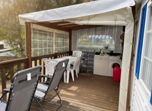 een terras met een tafel en stoelen op een dek bij Mobil Home sans vis a vis in Saint-Georges-de-Didonne