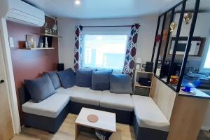 een woonkamer met een bank en een tafel bij Mobile Home 127 Bois Dormant in Saint-Jean-de-Monts