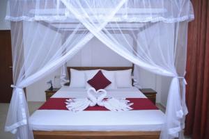 - une chambre avec un lit à baldaquin blanc dans l'établissement Blue Horizon Villa - Rathgama, à Ratgama Hegoda