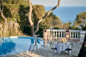 a table and chairs next to a swimming pool at Grand-Hôtel du Cap-Ferrat, A Four Seasons Hotel in Saint-Jean-Cap-Ferrat +90 photos