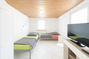 ein Zimmer mit zwei Betten und einem Flachbildfernseher in der Unterkunft GMA Apartment B3-1 in Mahlberg