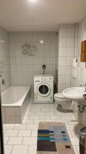 ein Badezimmer mit Badewanne und Waschmaschine in der Unterkunft GMA Apartment B3-1 in Mahlberg + 16 Fotos