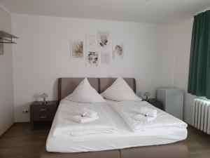 ein weißes Bett mit zwei weißen Handtüchern darauf in der Unterkunft Pension Clara in Tanneberg